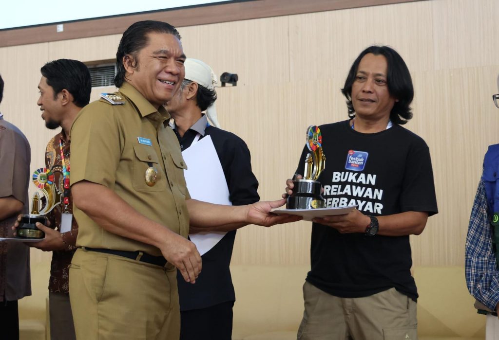 Pj Gubernur Banten memberikan trophy Banten SDGs Award 2024.