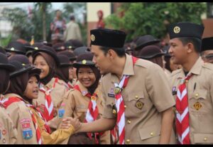 Ketua Kwarcab Kota Serang Nur Agis Aulia  menyalami peserta pramuka.