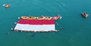 HUT RI ke-80, AKSI dan FOTSAR Banten Kibarkan Merah Putih Raksasa di Laut Merak.
