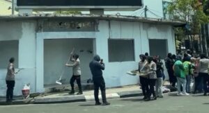 Anggota Kepolisian sedang lakukan cat ulang pos polisi ciceri yang dirusak massa aksi.