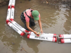 Pejuang sungai sedang memasang barrier untuk menghadang sampah di sebuah sungai di Bali. (Foto:ripcurl).